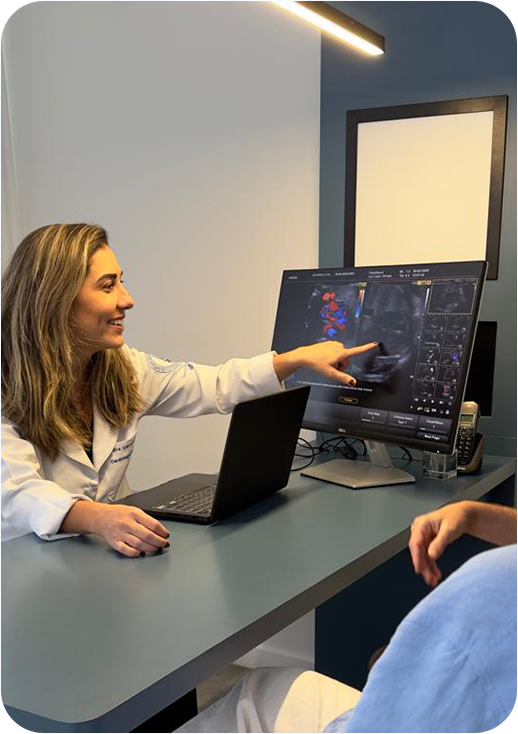 Dra. Lianna Kaizer apontando para imagem de ecocardiograma fetal no monitor